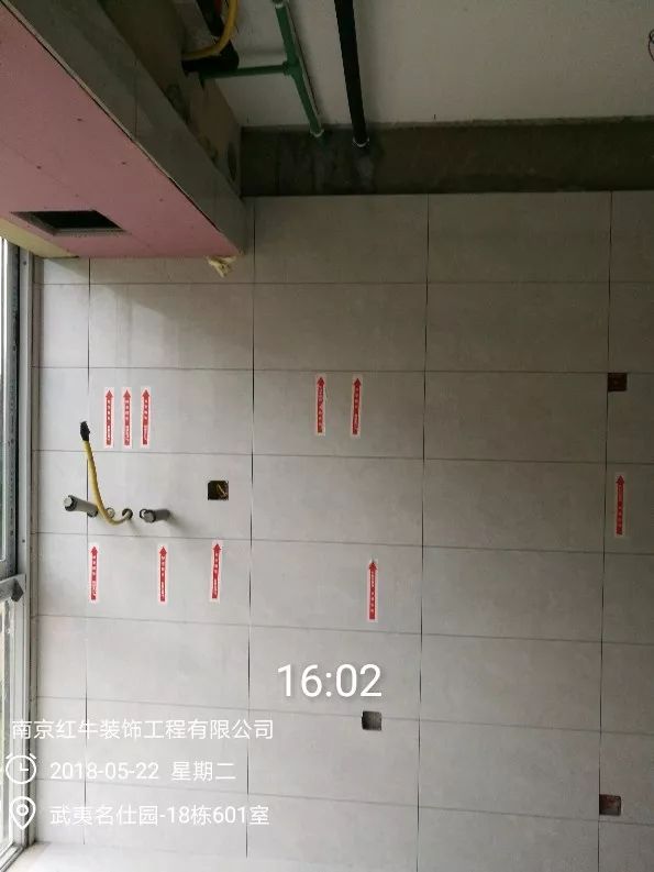 南京武夷名仕園124平米簡(jiǎn)美風(fēng)格裝修  享受家?guī)?lái)的溫度30五月份_墻磚鋪貼完成后，紅牛裝飾的工人會(huì)用專用護(hù)角條對(duì)瓷磚角保護(hù)，用標(biāo)貼標(biāo)出水管、線管走向示意。